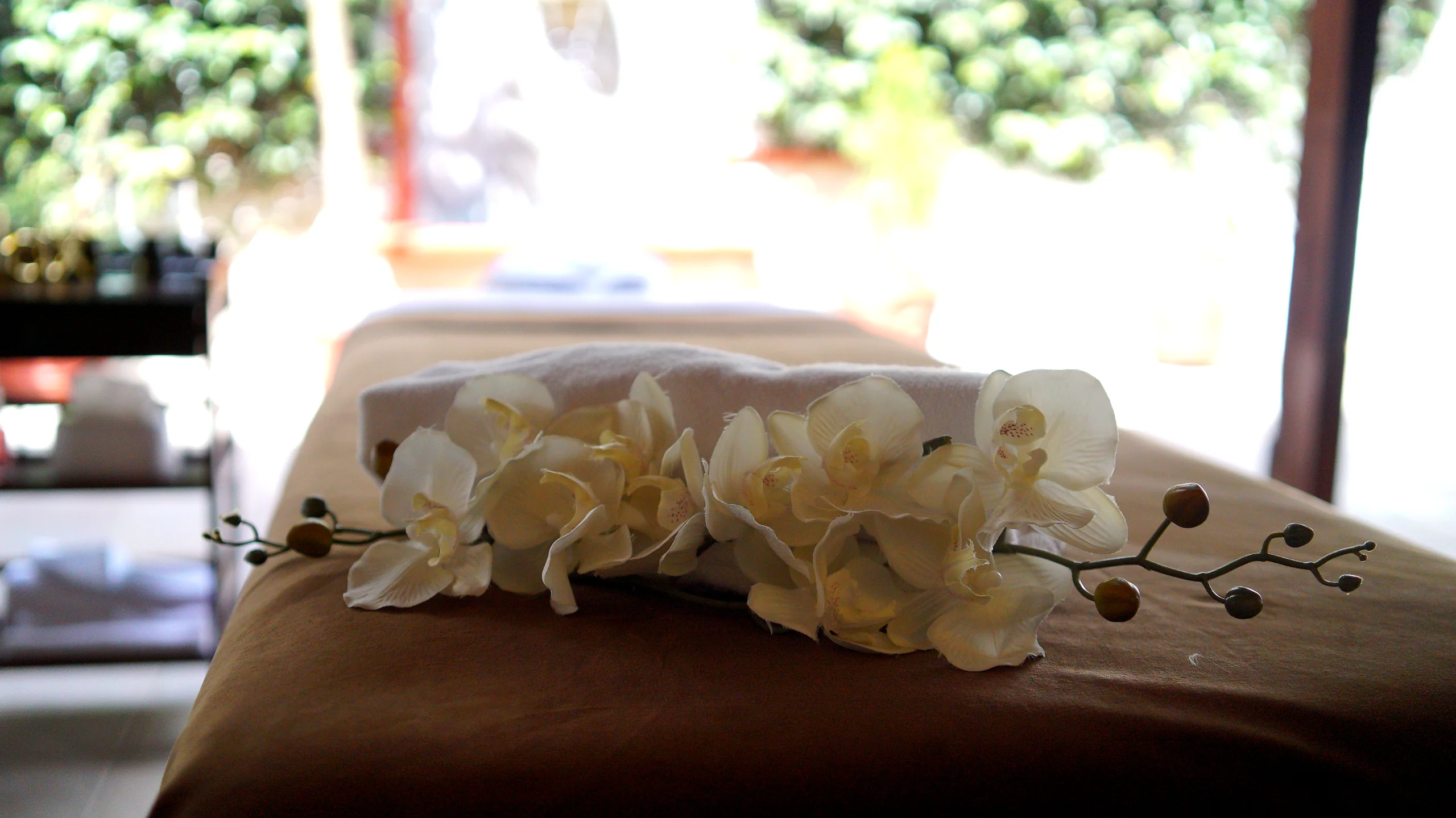 Camilla de masajes preparada con orquídeas blancas en Kinesioterapeutas, clínica de masajes y fisioterapia en San Felipe del Agua, Oaxaca.